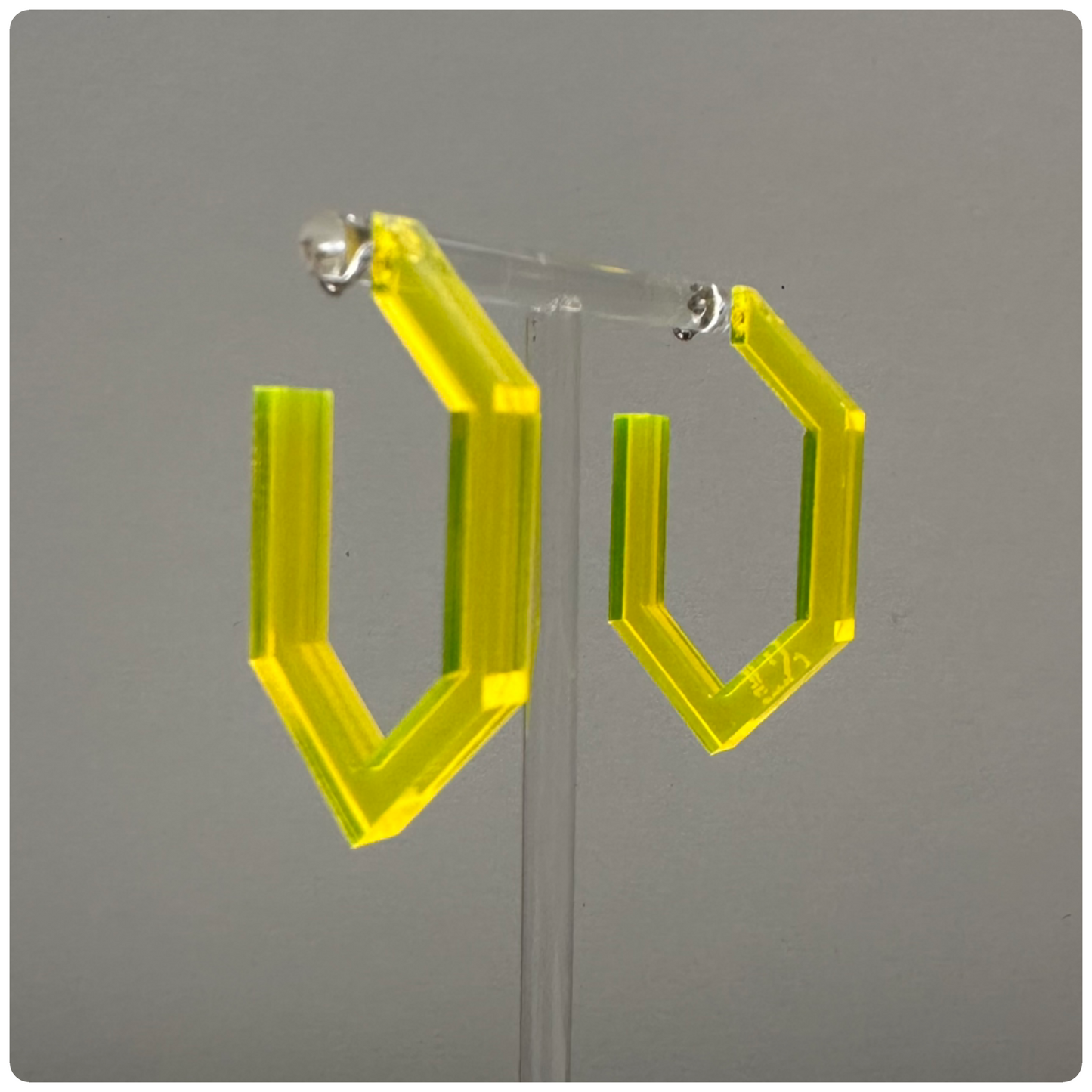 Lucite Modern Hoop Earrings
Handcrafted in the USA | Unique Statement Pieces

Add a bold touch of color and modern elegance with these stunning handcrafted Lucite hoop earrings. Made with sterling silver posts, these hoops are available in three eye-catching colors: neon yellow, neon pink, and smokey grey. A perfect way to elevate your style with a pop of vibrant color!
